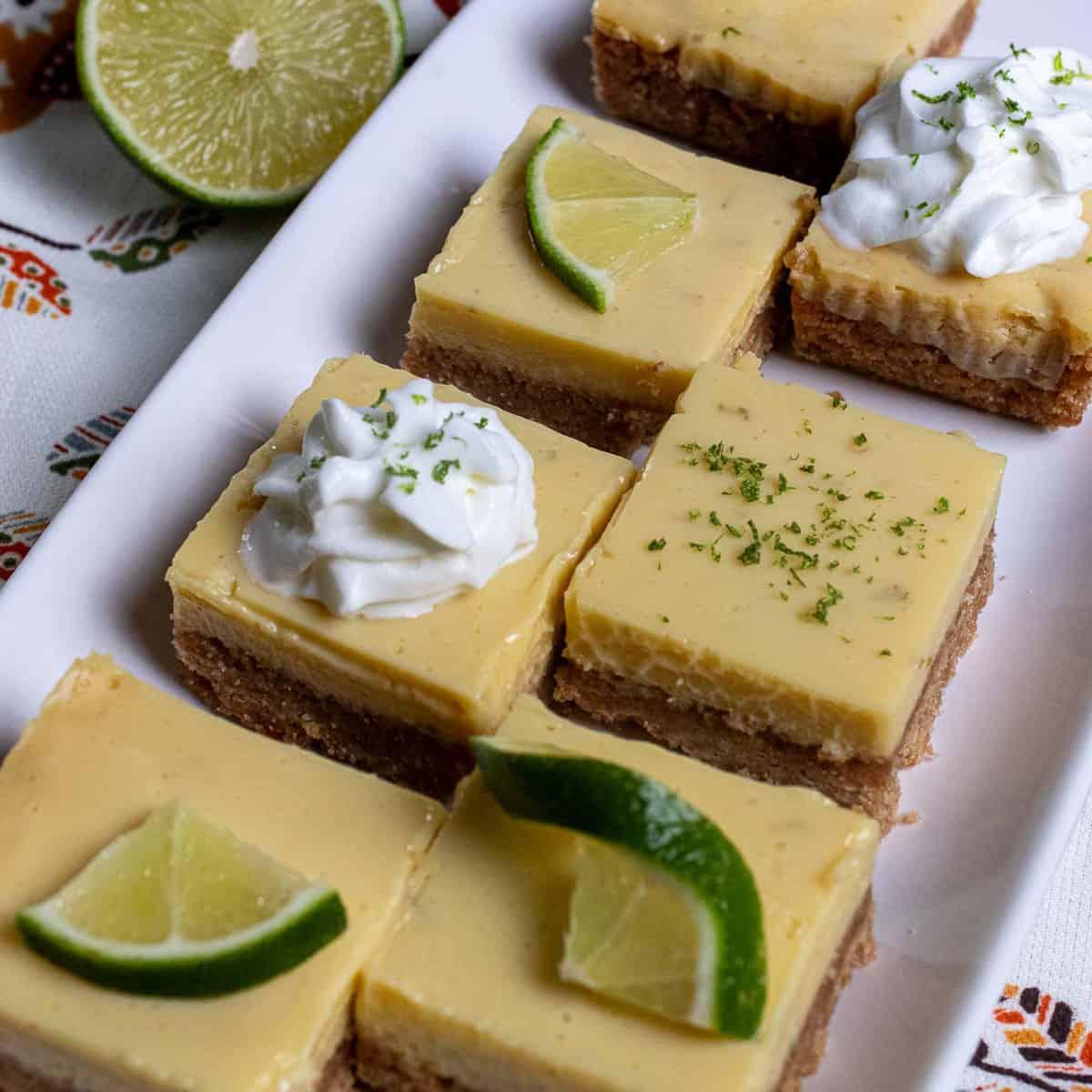A platter of key lime pie bars being served at a party