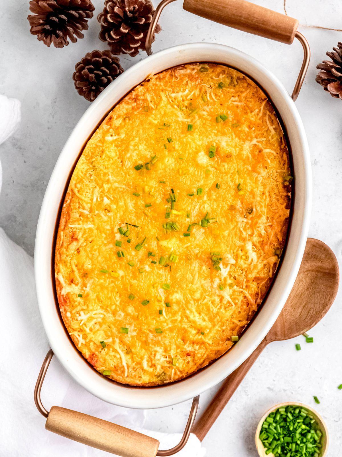Golden brown baked corn casserole with savory herbs, steaming hot