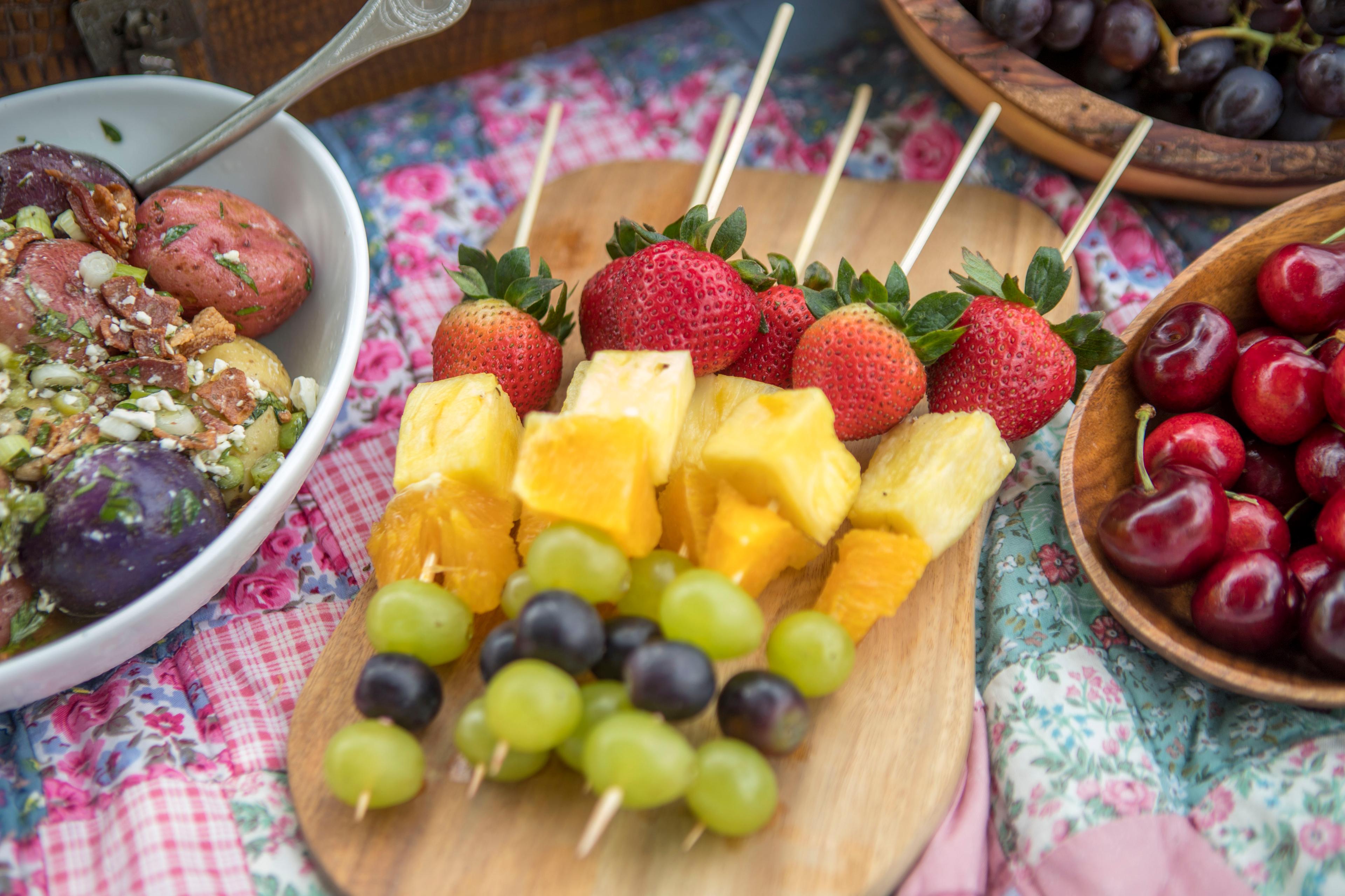 Colorful fruit skewers on a summer picnic table