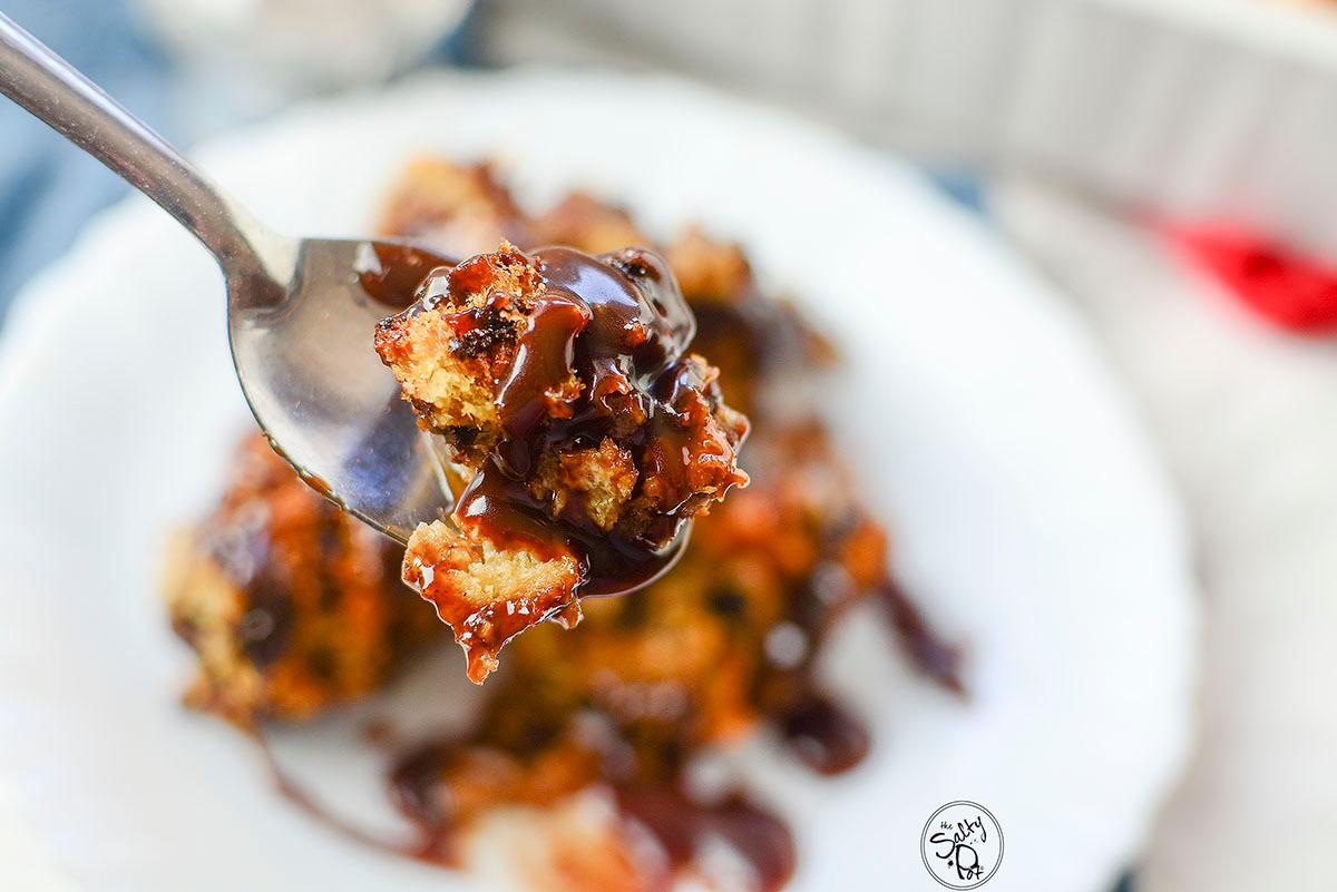 Close-up shot of a slice of warm bread pudding with melting chocolate chips and pecans