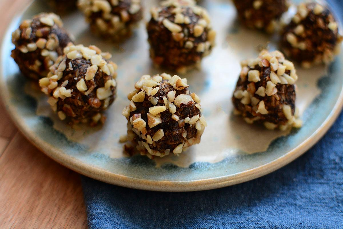 Close-up of a person rolling walnut and date bliss balls