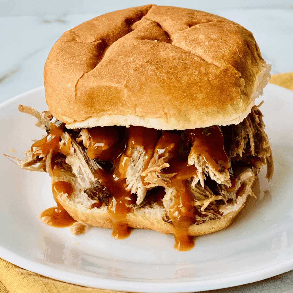 Juicy pulled pork piled high on a burger bun with all the fixings