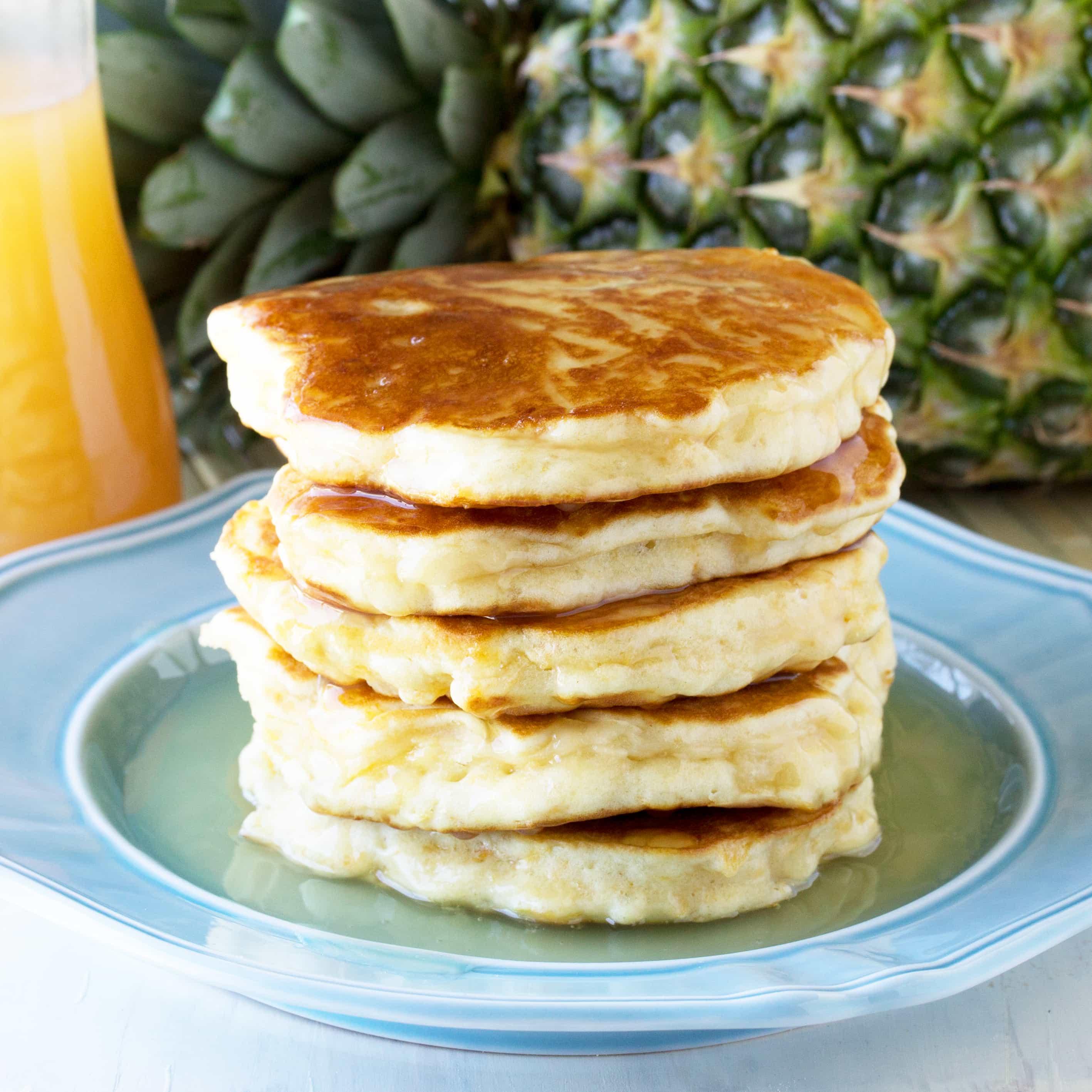 Delicious pineapple pancakes with coconut flakes, golden brown and fluffy, served on a plate with syrup