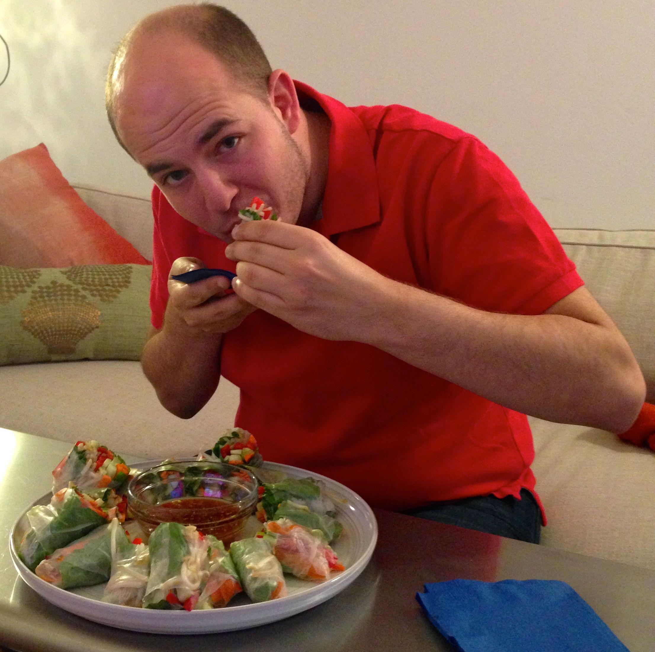 Someone happily eating a spring roll