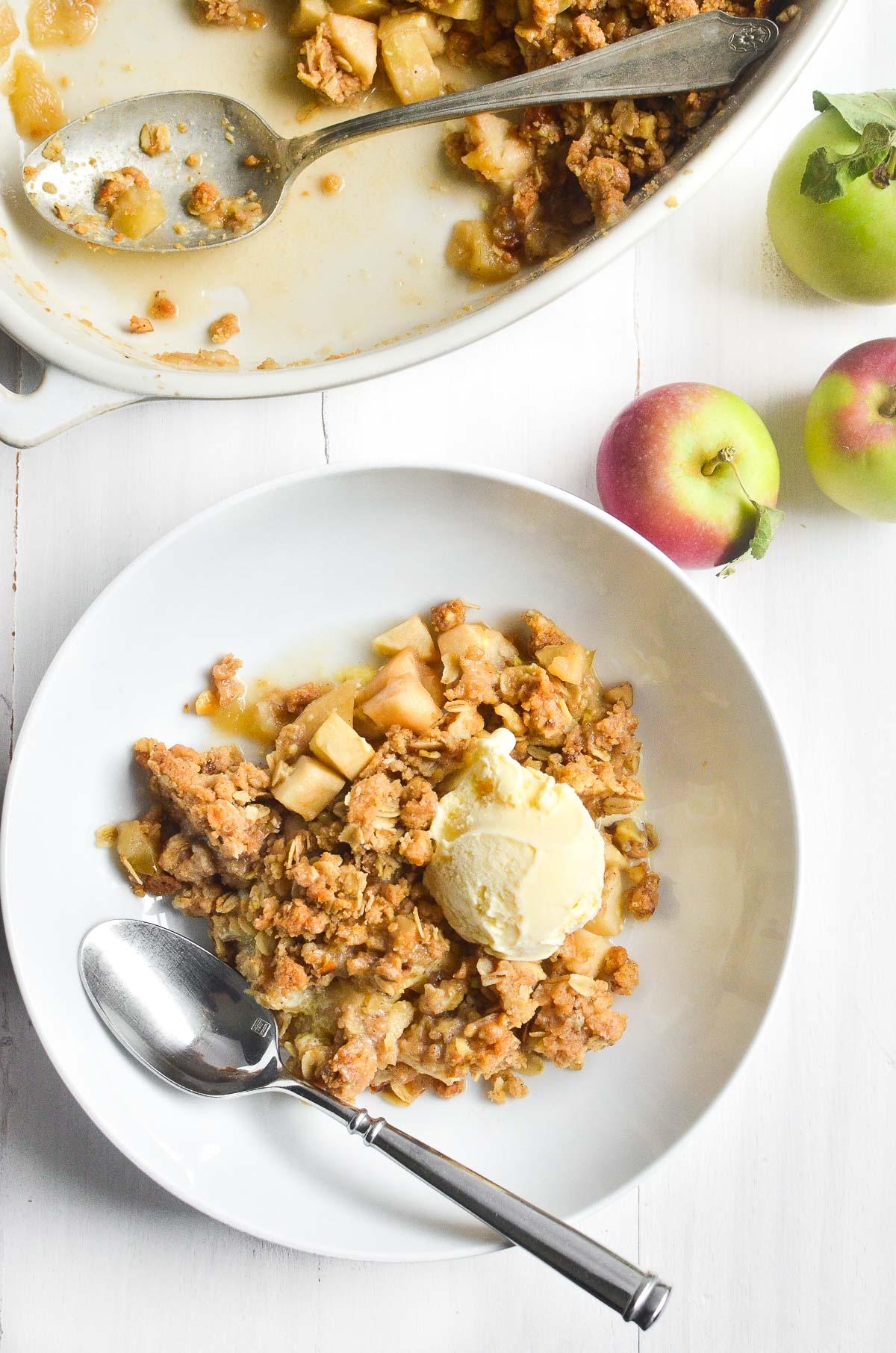 close up shot of a slice of walnut apple crisp being lifted from a baking dish with a server