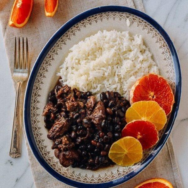 A plate of feijoada with a wedge of Minas cheese