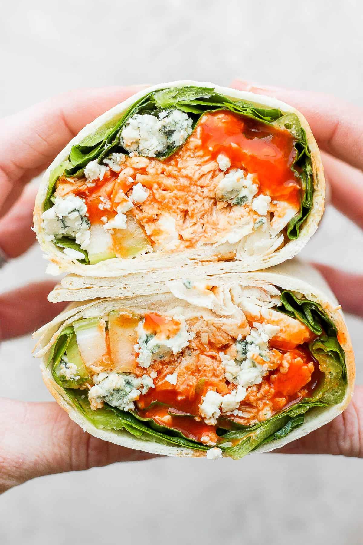 A person enjoying a buffalo chicken ranch wrap