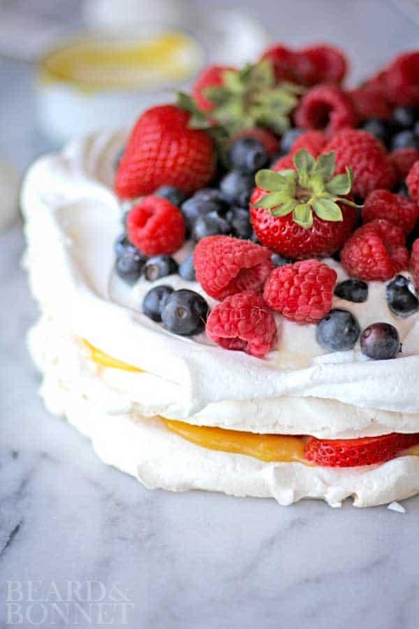 a slice of mixed berry pavlova being lifted with a fork