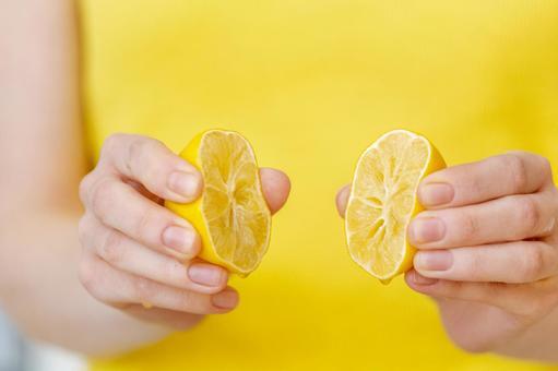 Close-up of hands squeezing lemons and oranges