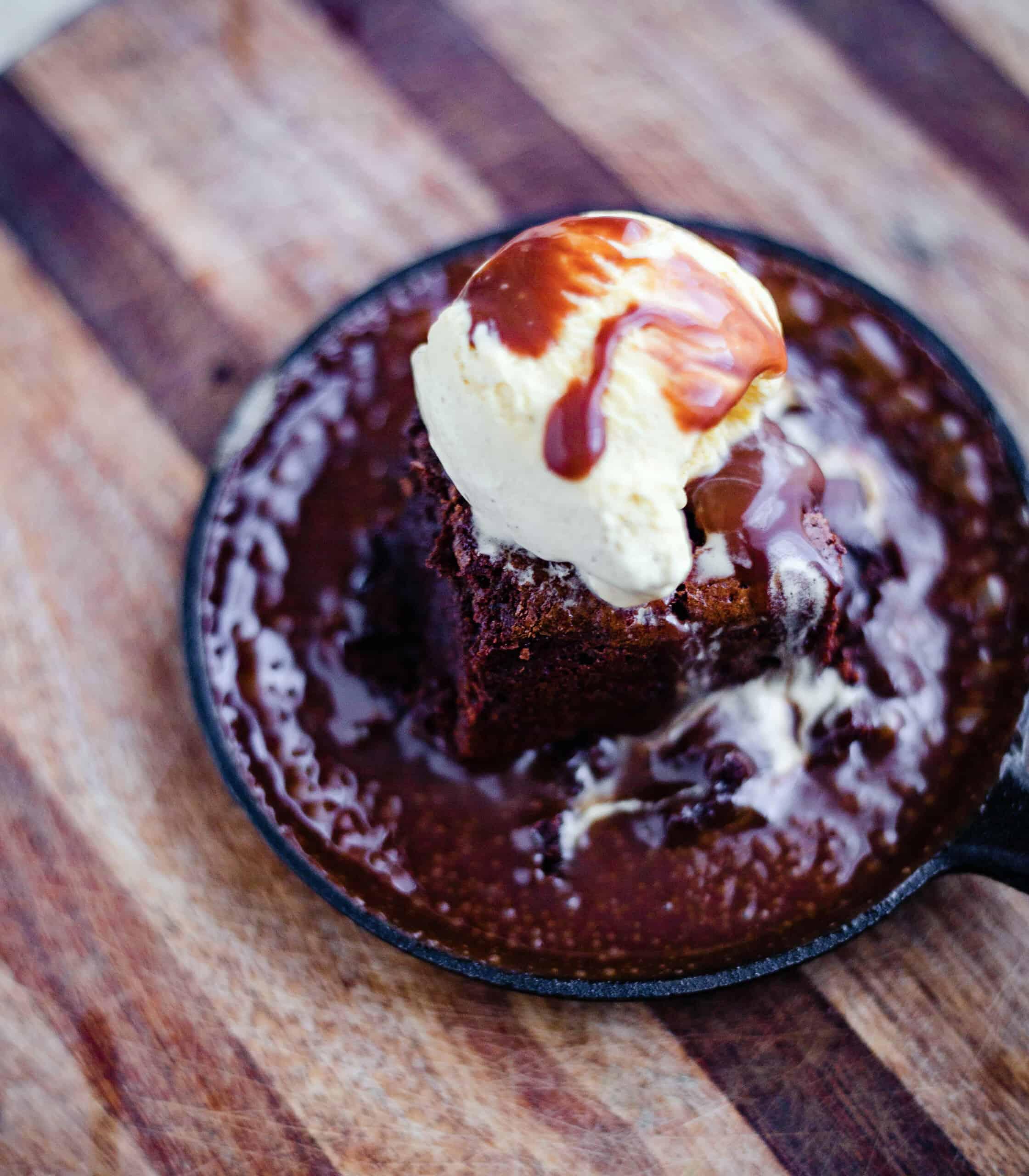 A plate of warm, gooey brownies with a scoop of ice cream