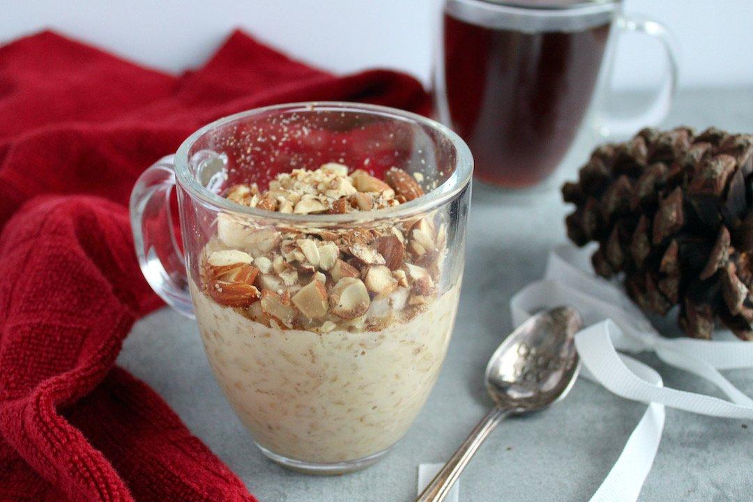 Eggnog oatmeal bowl with various toppings arranged on the side