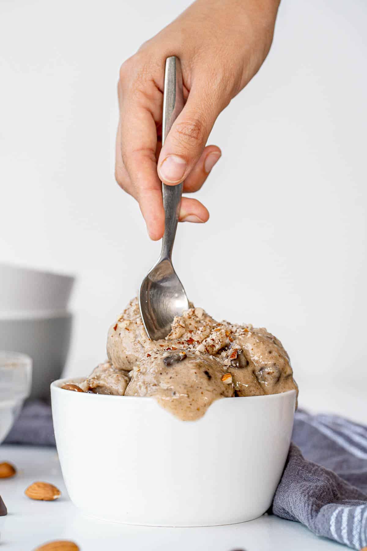 Person holding a spoon of dairy-free mocha almond fudge ice cream