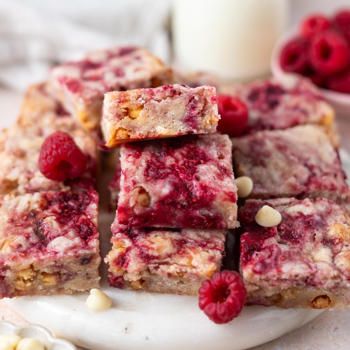 Close-up shot of gooey raspberry blondies with a dusting of powdered sugar