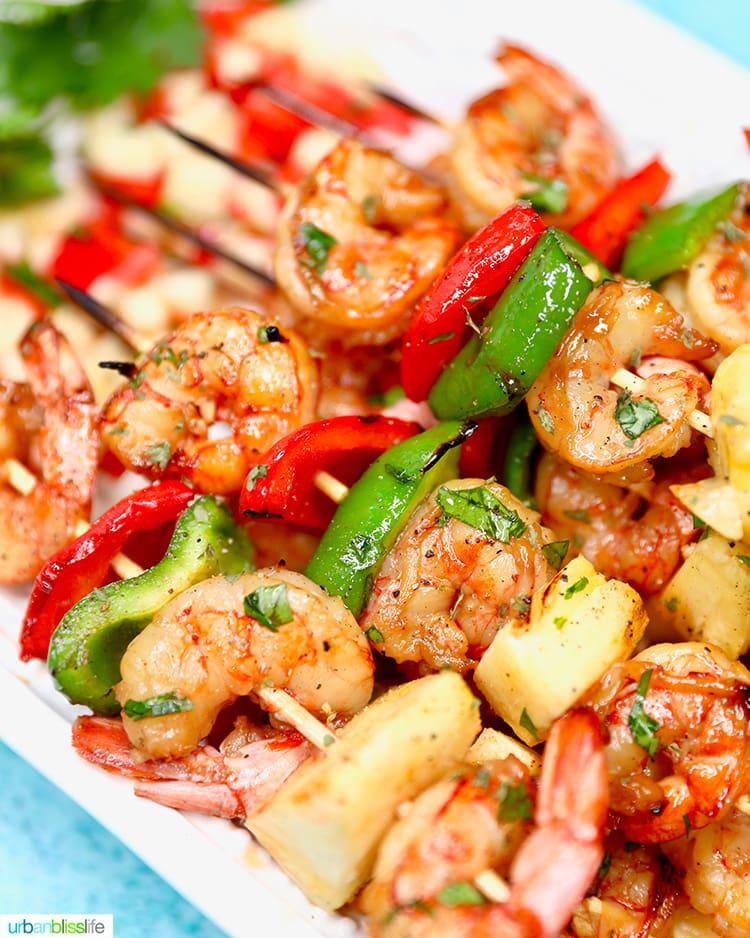 close-up shot of perfectly grilled shrimp skewers with pineapple and bell pepper, glistening under the sunlight