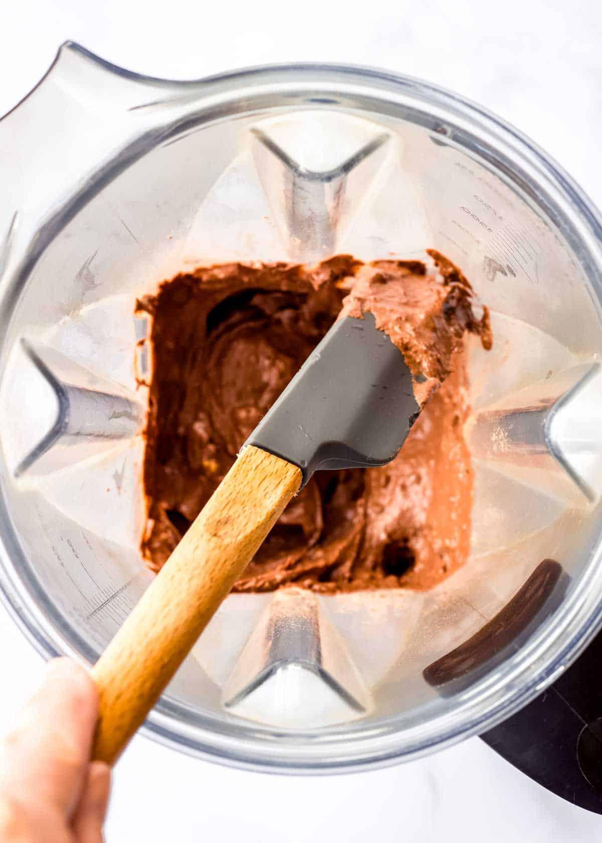 A close-up shot of a blender with chocolate avocado mousse being blended