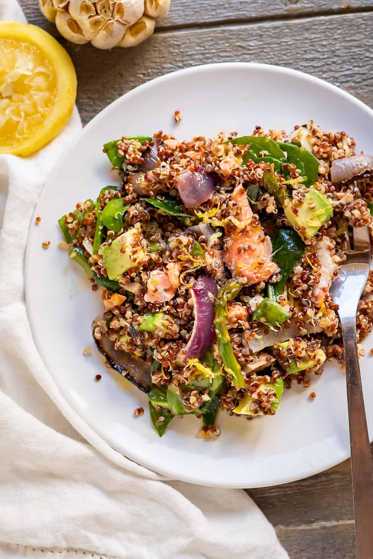 Close-up shot of a bowl of quinoa salad with salmon and asparagus, highlighting the vibrant colors and textures.