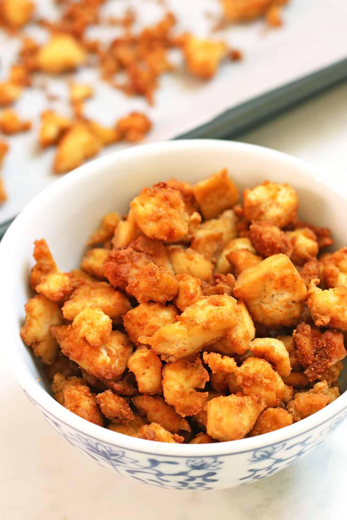 Close-up of tofu being crumbled in a bowl