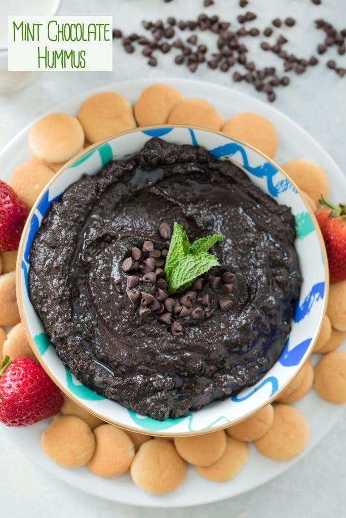 A bowl of chocolate hummus garnished with fresh mint leaves and a drizzle of olive oil