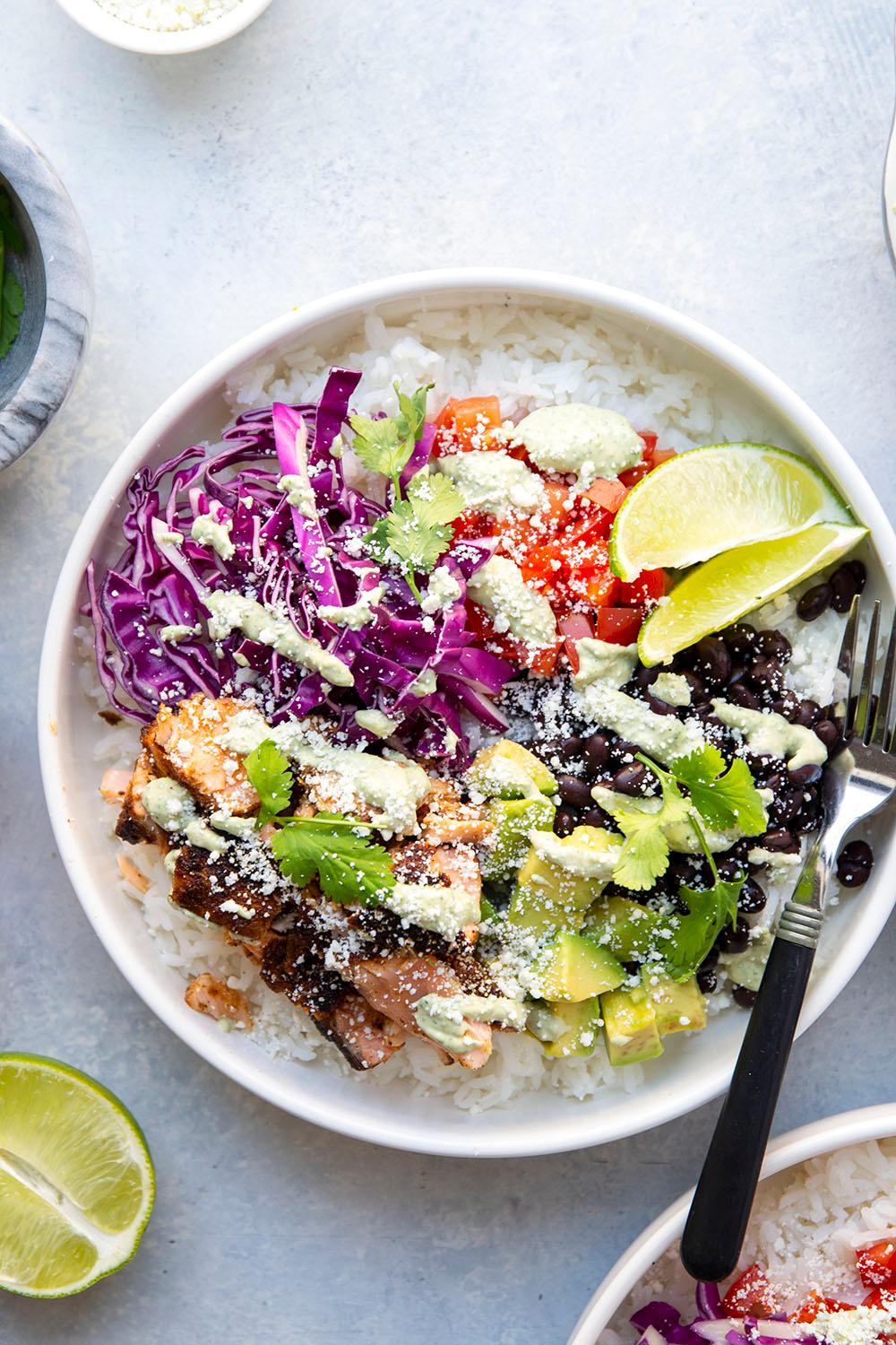 overhead shot of completed blackened fish rice bowl with lime wedge and cilantro garnish.