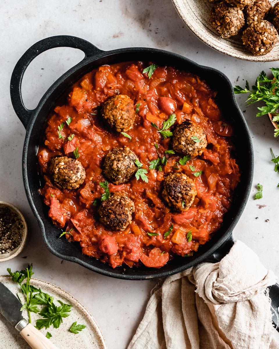 A close-up shot of plant-based meatballs in sauerbraten sauce, highlighting the texture and color
