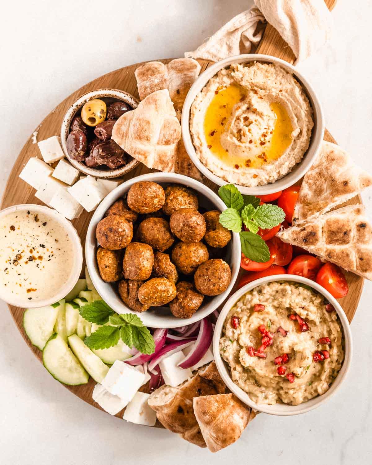 A person assembling the Mediterranean Falafel Platter