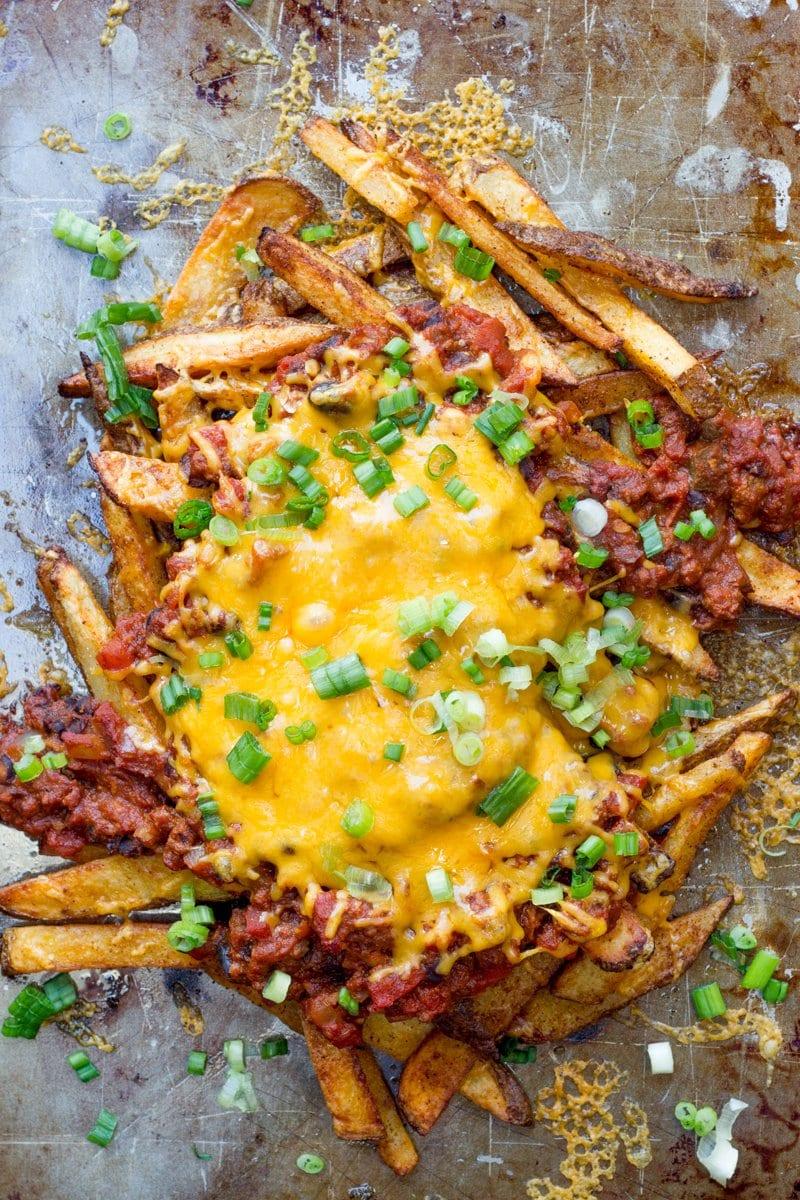 Close-up of a bowl of chili cheese fries dip with crispy fries on top