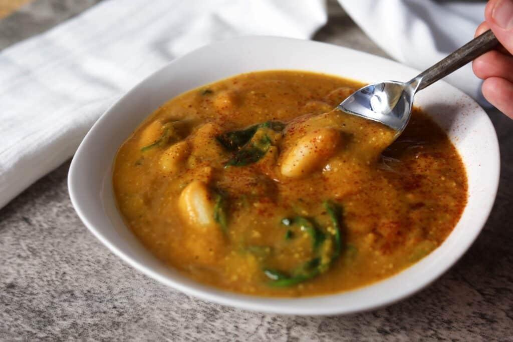 close-up shot of pumpkin gnocchi soup with brown sage butter in a rustic bowl