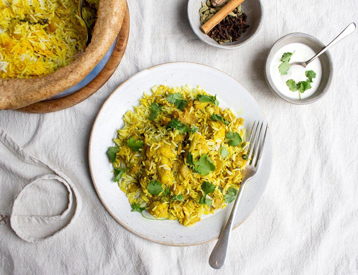 Close-up shot of a bowl of Spicy Cauliflower & Potato Biryani, showcasing the vibrant colors and textures