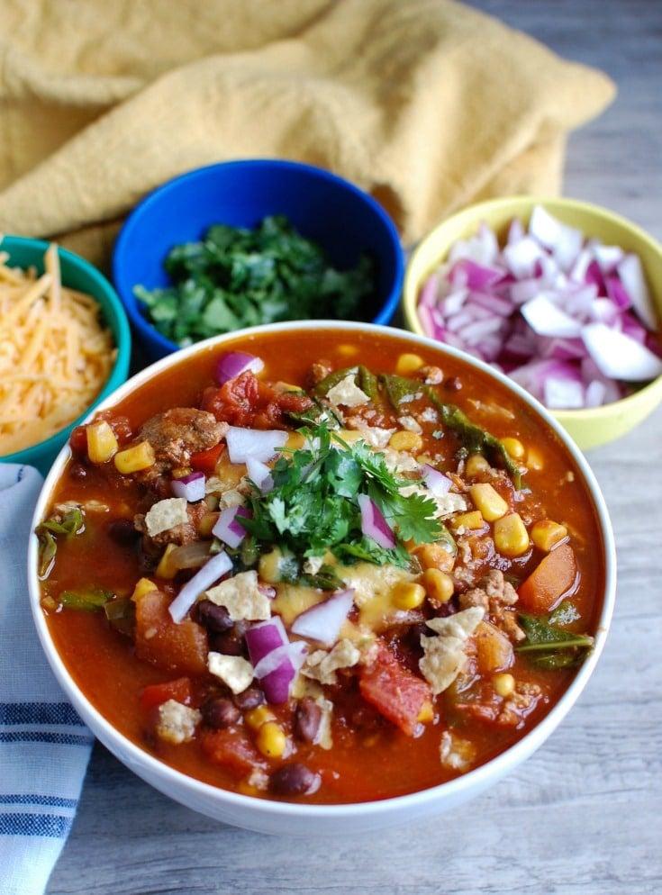 A close-up shot of a bowl of slow cooker kale chili, showing the texture and ingredients.