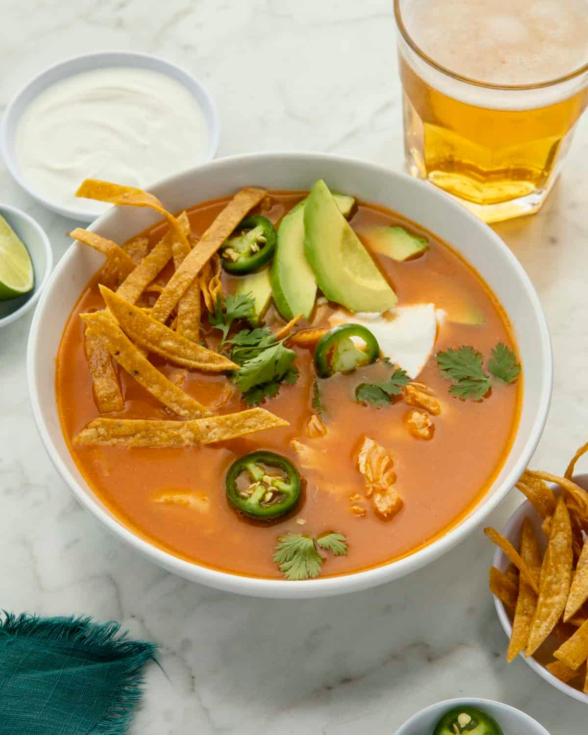 A table set for a meal with a bowl of Chicken Tortilla Soup in the center