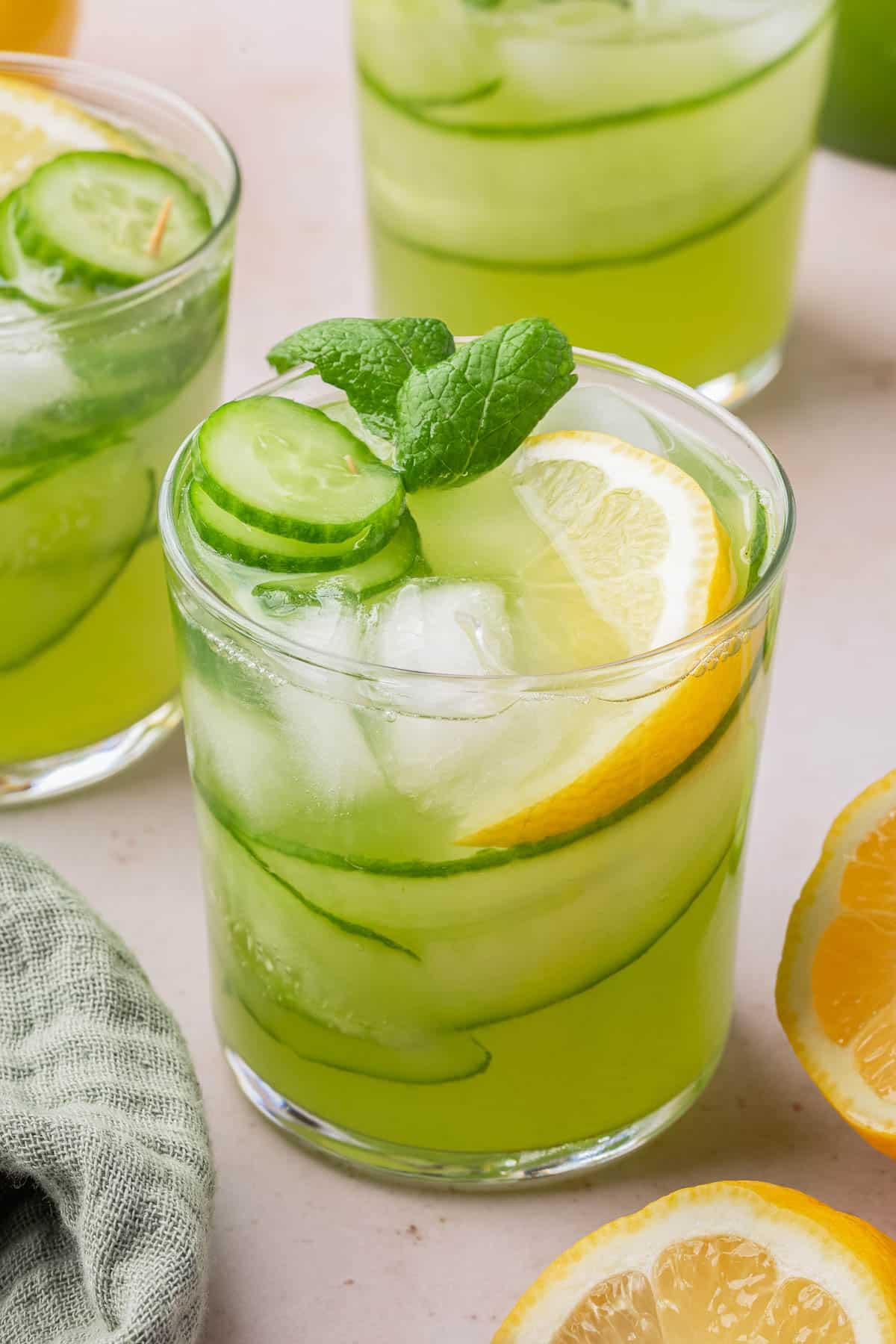 Refreshing glass of cucumber mint limeade with ice and lime wedge