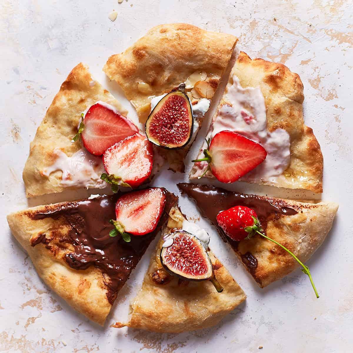 Close-up of sliced churro pizza showing the fruit toppings and churro base