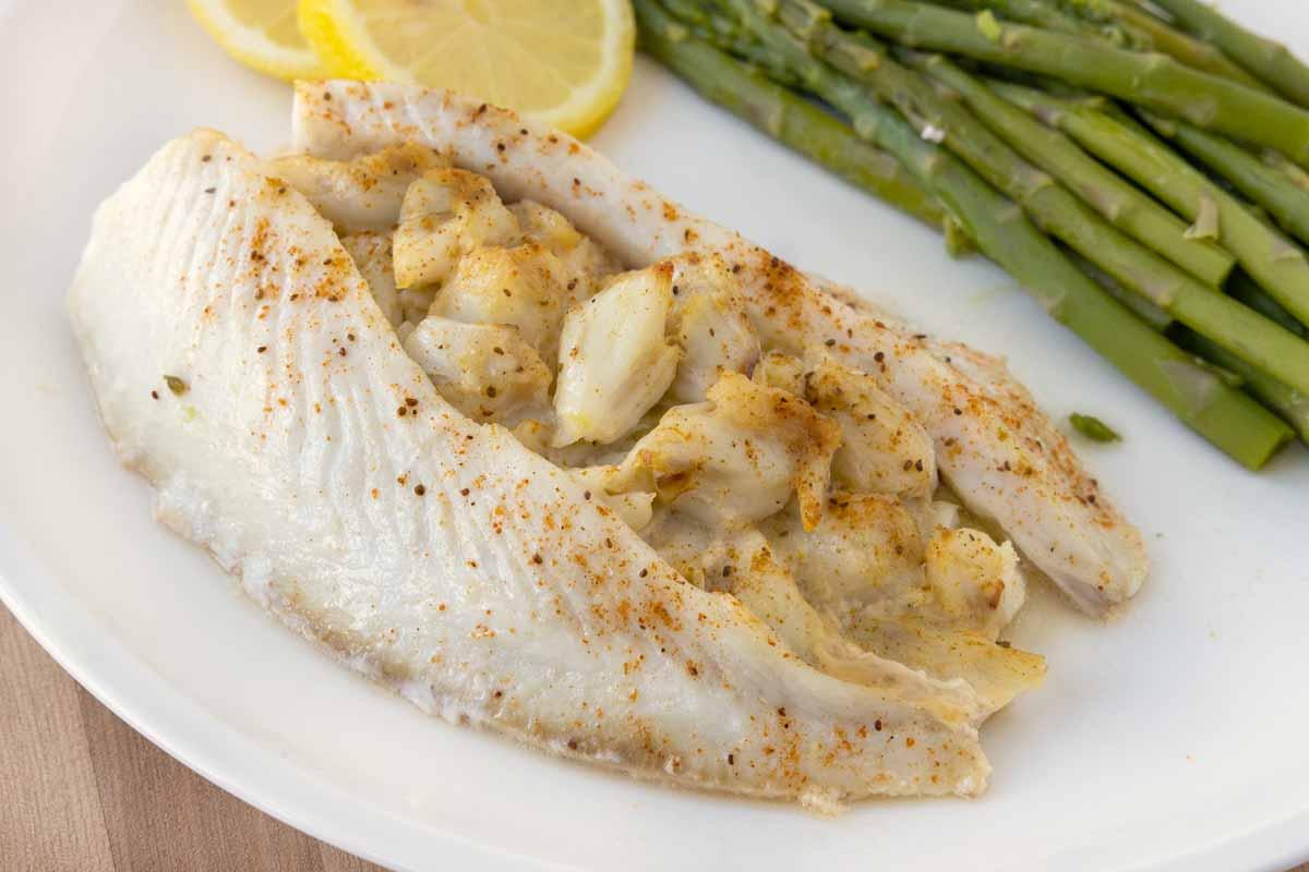 Close-up shot of a baked crabmeat-stuffed flounder fillet, garnished with fresh parsley