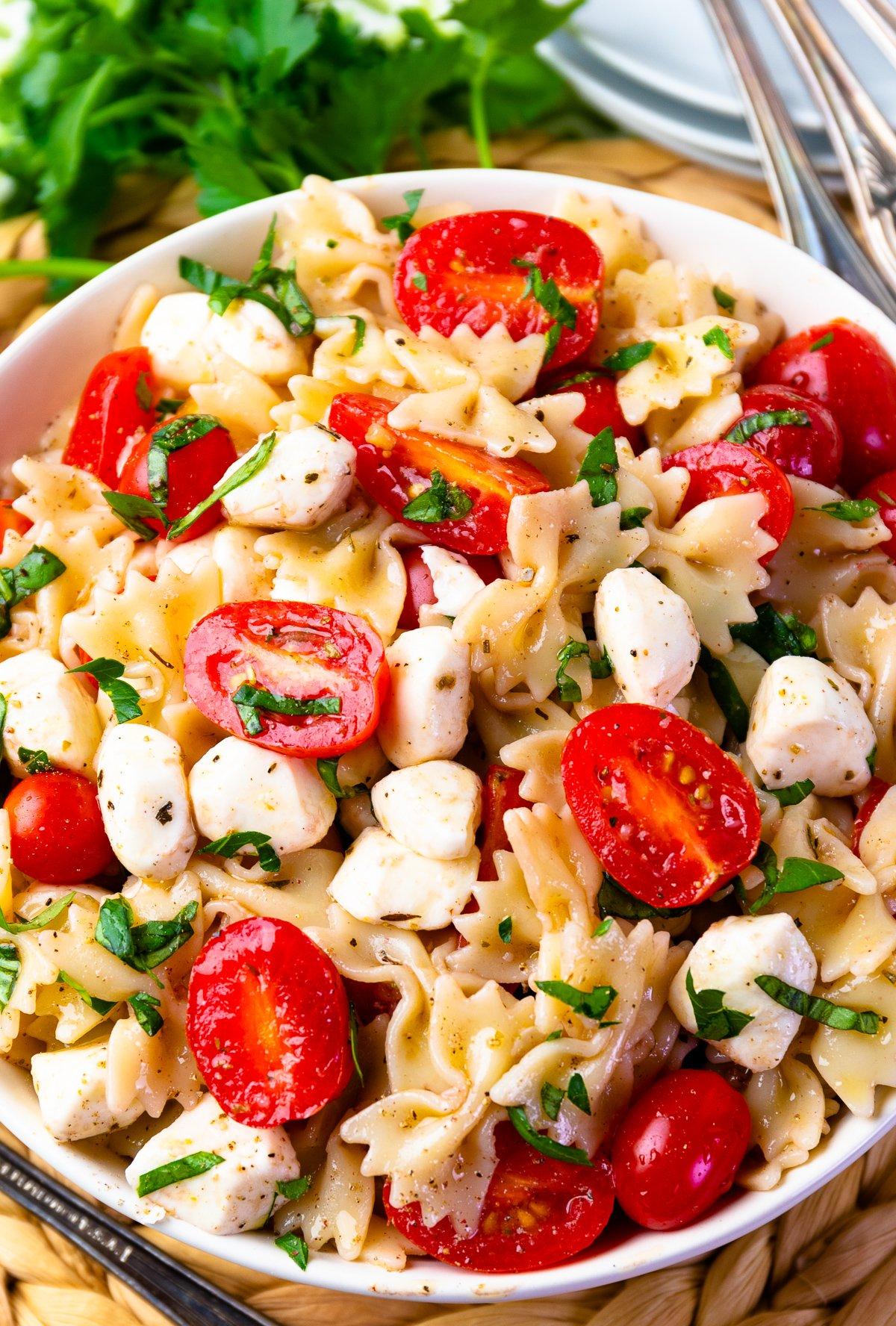 close up of pasta salad with cherry tomatoes and buffalo mozzarella balls