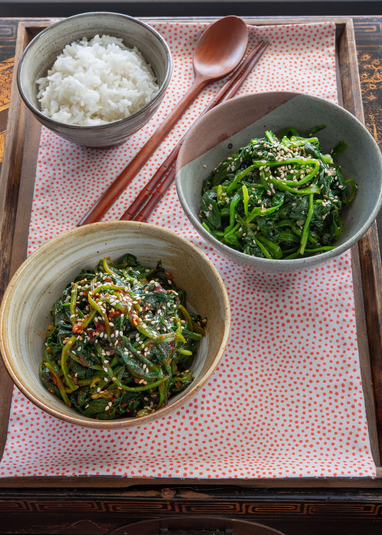 family enjoying a meal together, with kimchi and spinach namul on the table