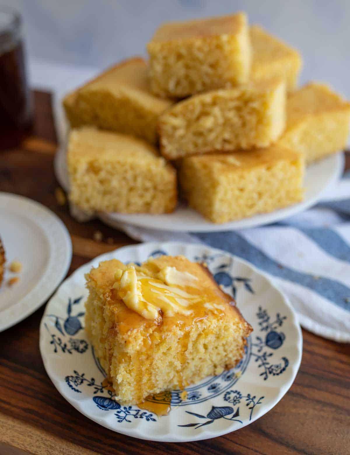A family enjoying a slice of warm cornbread alongside a hearty meal.