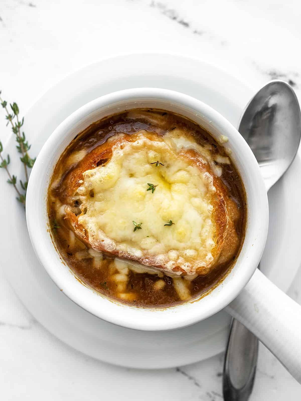 A person enjoying a bowl of cashew cheese French onion soup in a cozy setting