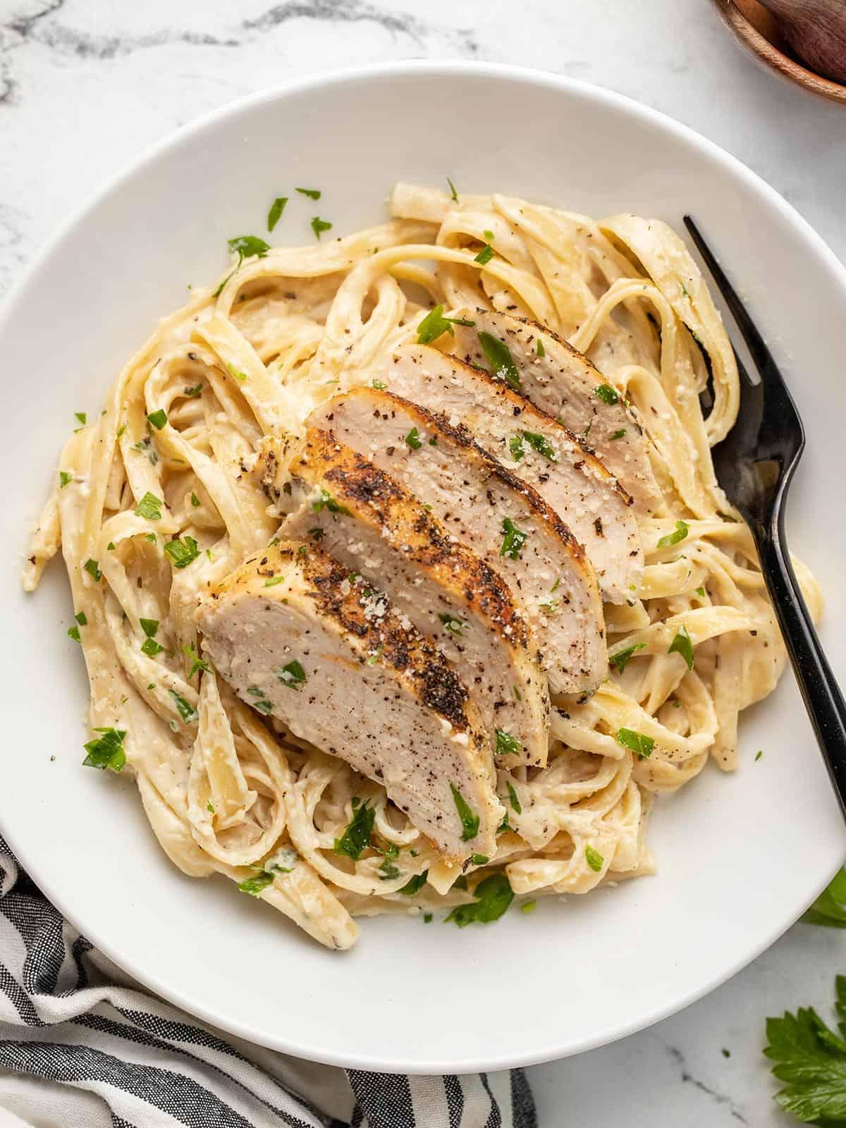 close up shot of chicken alfredo pasta with creamy sauce
