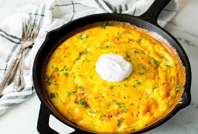 A whole Mexican Fritatta in a cast iron skillet, garnished with fresh cilantro