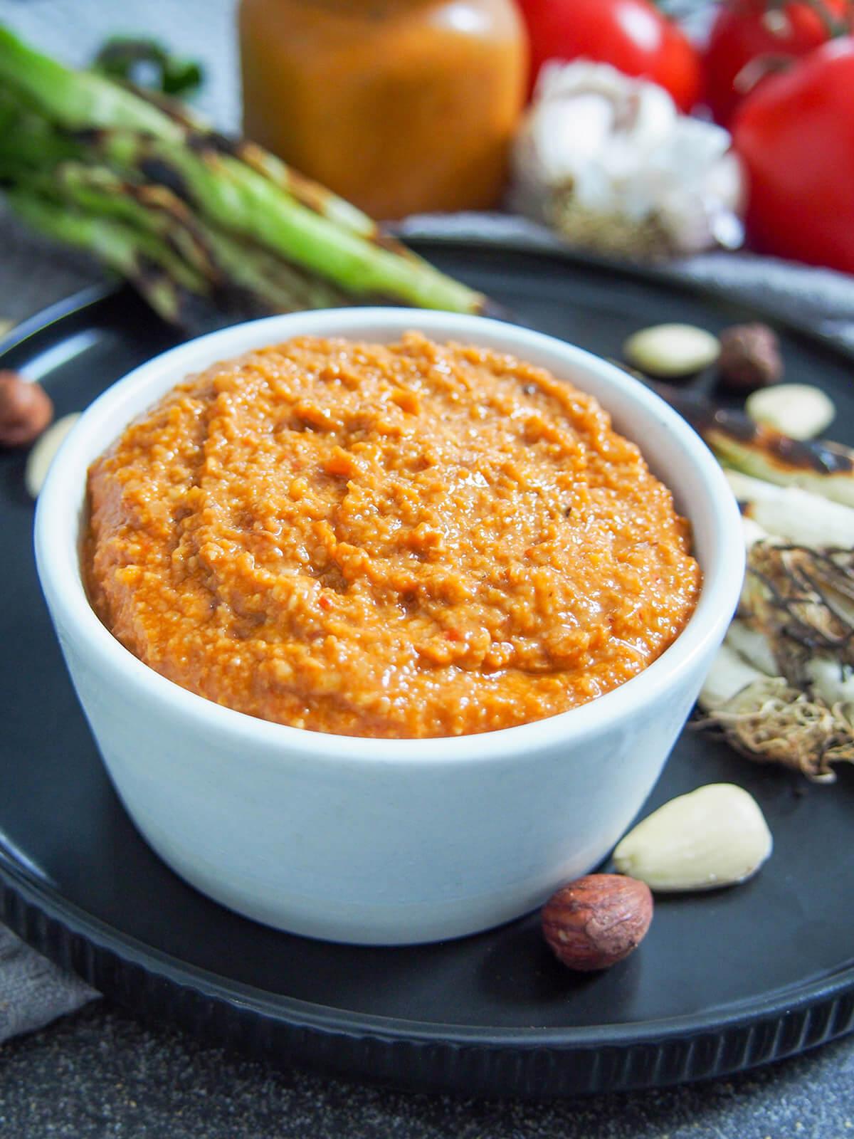 Close-up shot of a bowl of romesco sauce with roasted red peppers and toasted almonds.