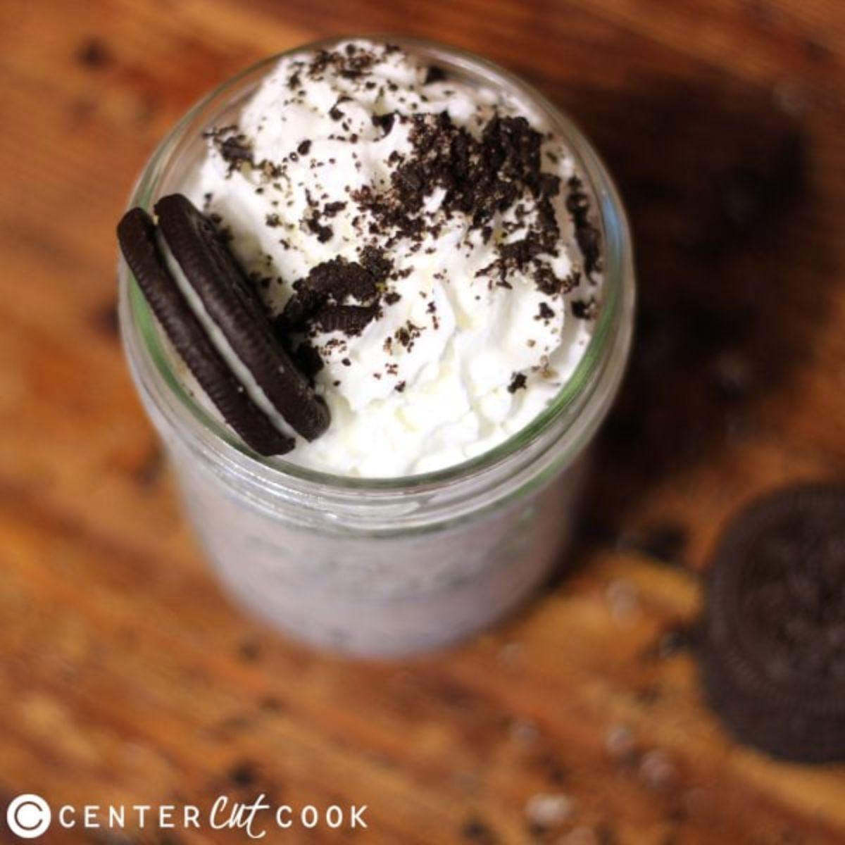 Close-up shot of a Cookies and Cream Smoothie in a glass with cookies and cream on the rim.