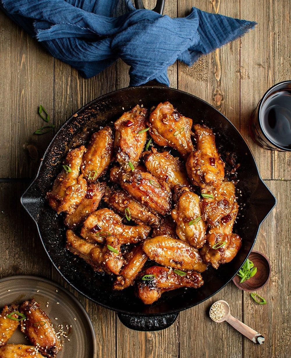 Close-up shot of Korean BBQ wings with sesame seeds, glistening and delicious