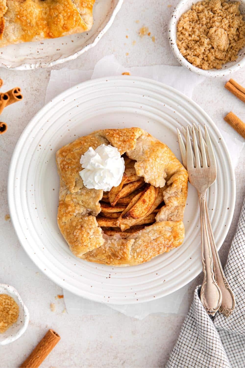 A rustic apple cinnamon tart with a flaky crust and glistening apples, garnished with cinnamon