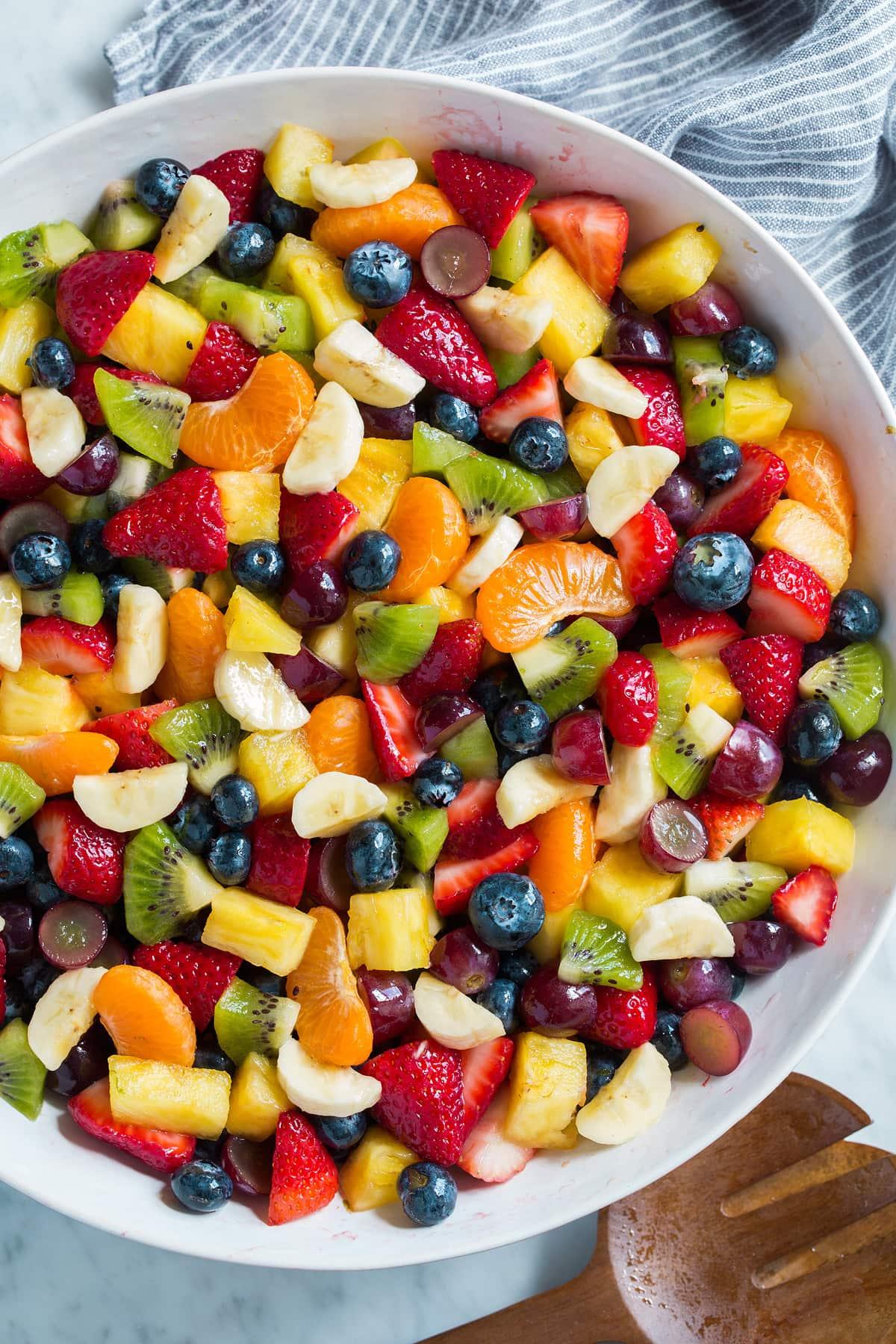 Close-up shot of a colorful fruit salad with a cardamom-honey dressing drizzle