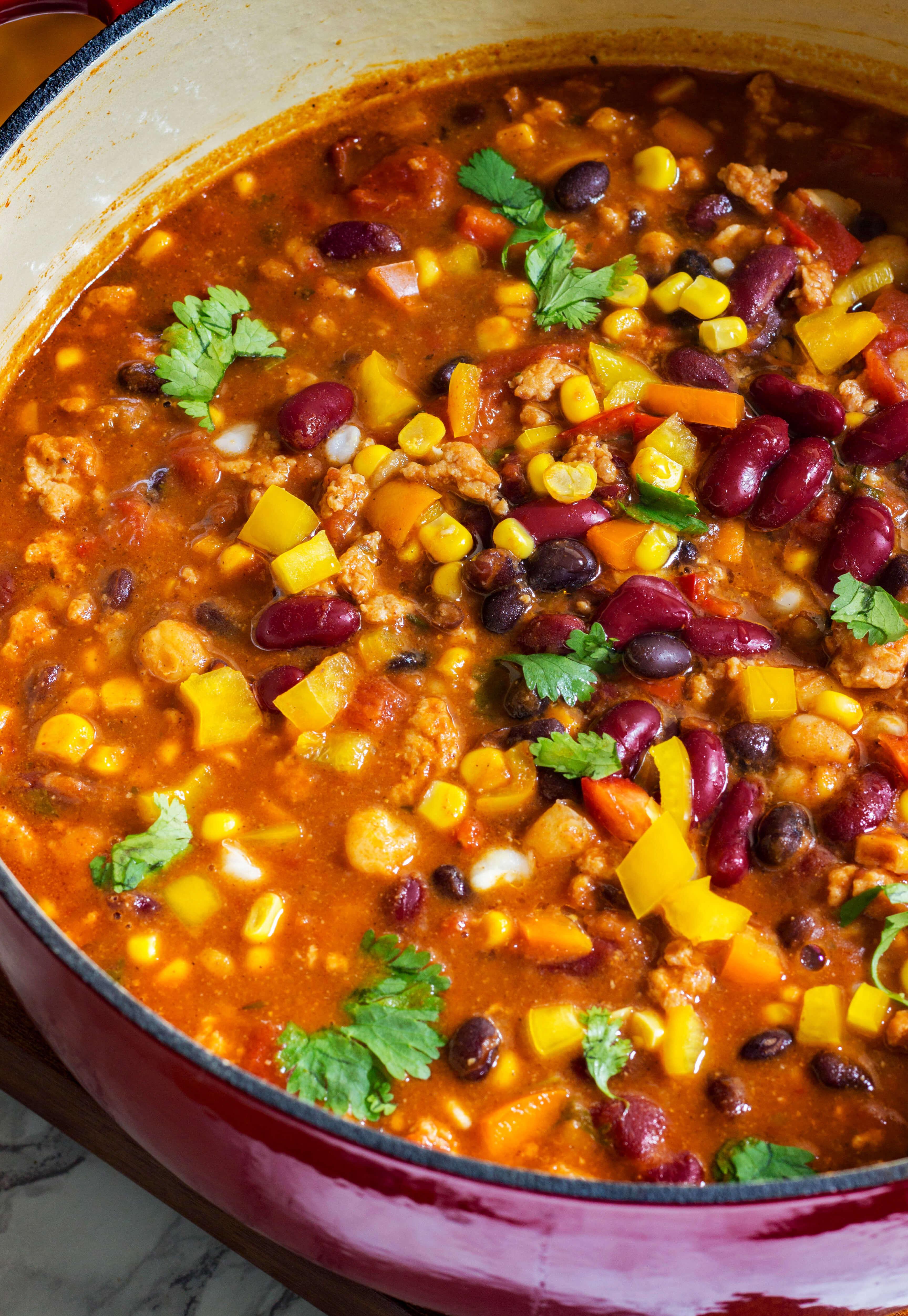Close-up shot of a bowl of jerk chicken chili, highlighting the vibrant colors and textures
