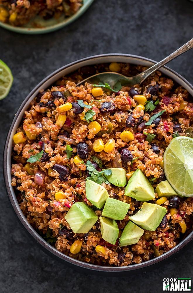 A close-up shot of a delicious bowl of Instant Pot Quinoa and Black Bean Rice, garnished with fresh cilantro and a lime wedge.