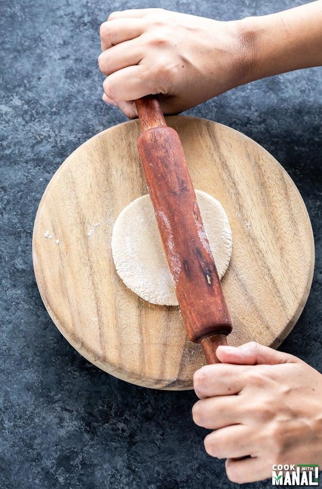 Someone rolling out roti dough