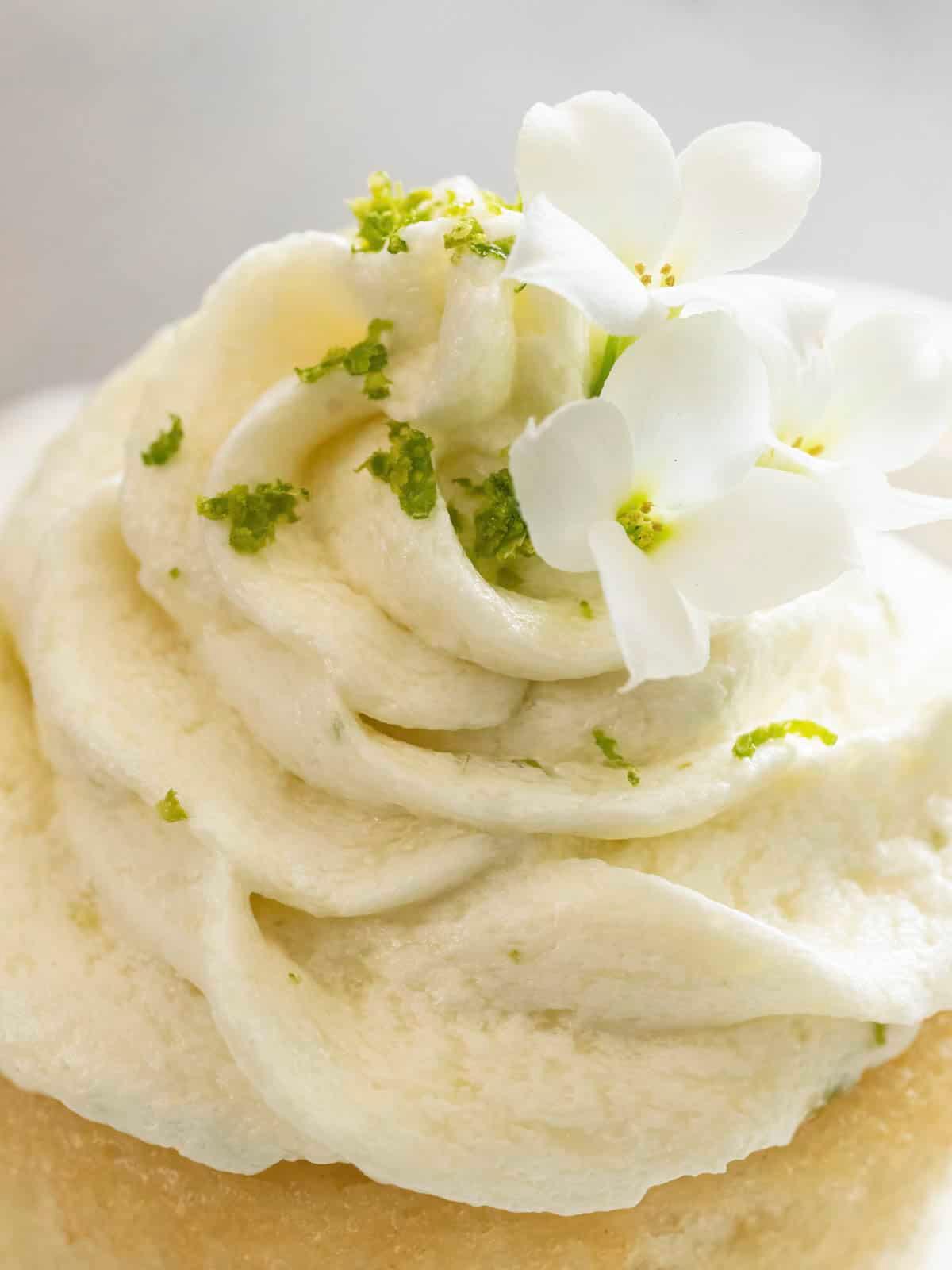 A person frosting key lime brownies with whipped cream