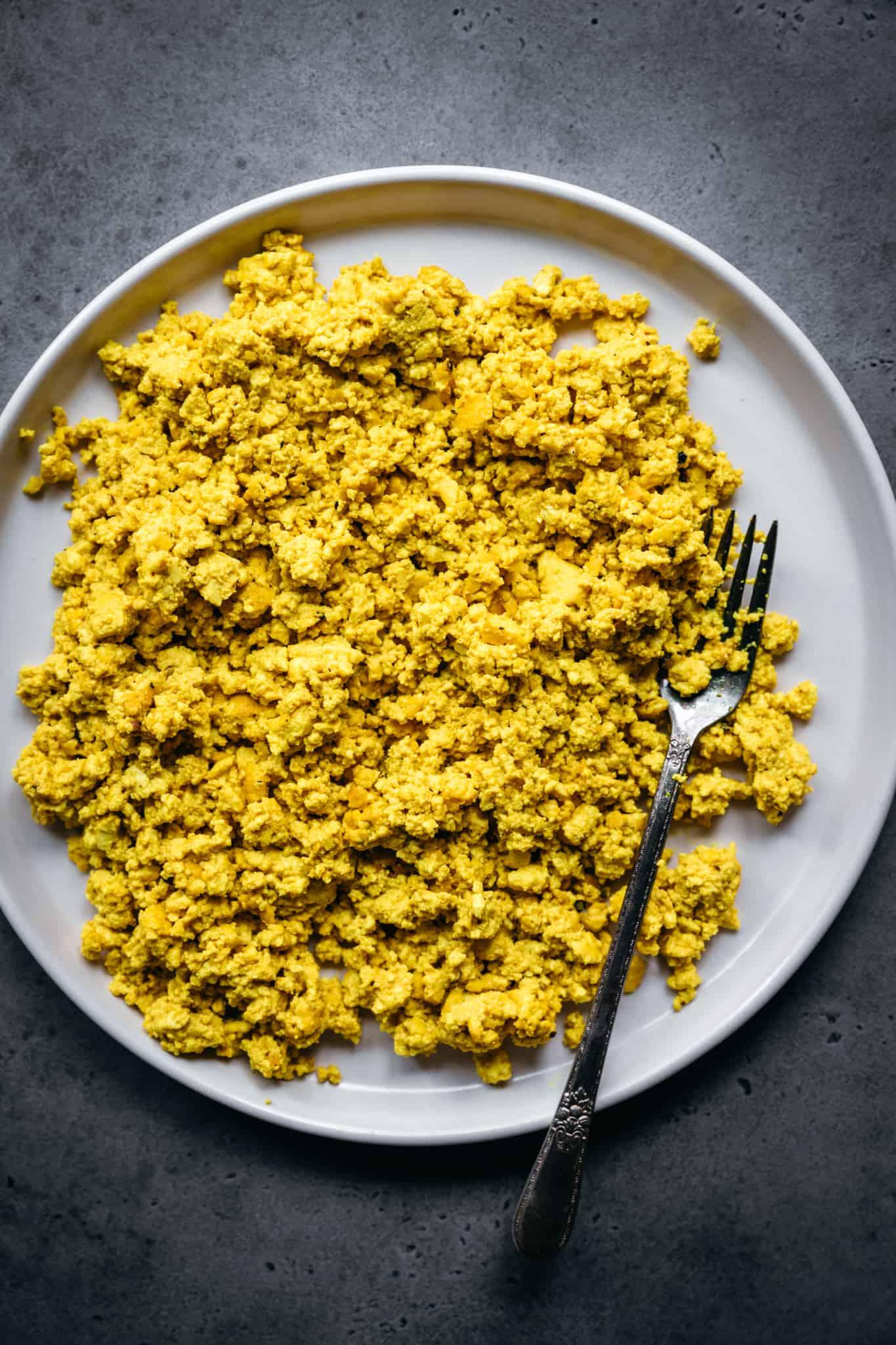 closeup of a plate of tofu scramble with vegan parmesan