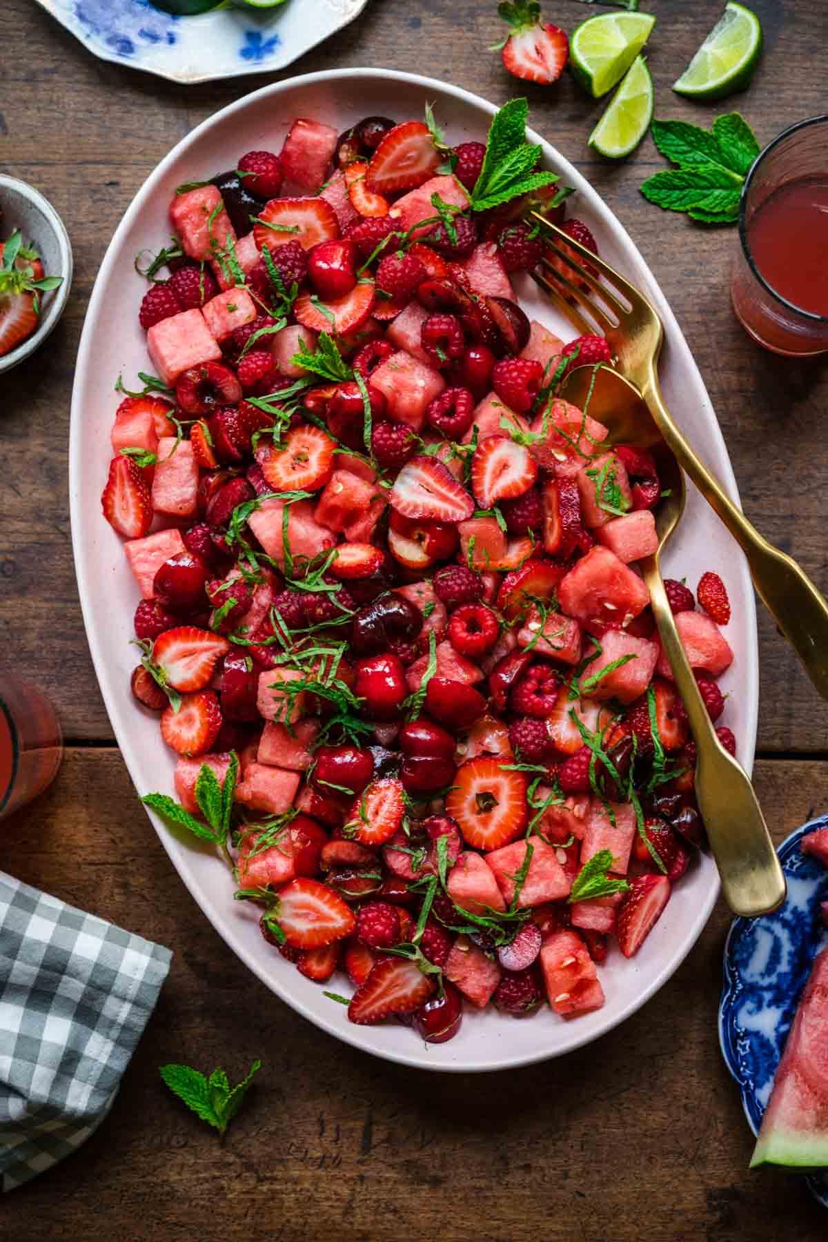 A beautifully plated strawberry watermelon salad with mint and lime, garnished with extra mint